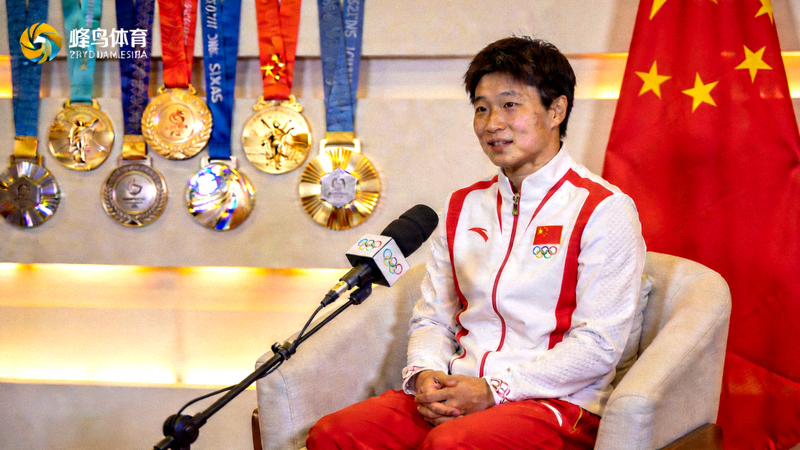 奥运冠军在蜂鸟体育演播室接受专访，背景是金牌和国旗